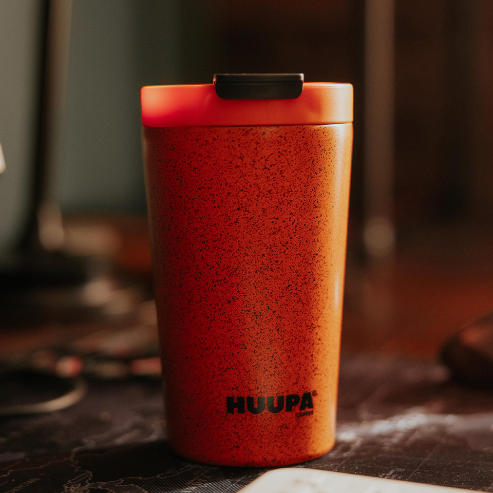 Orange Huupa thermos on a blurred background