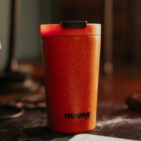 Orange Huupa thermos on a blurred background
