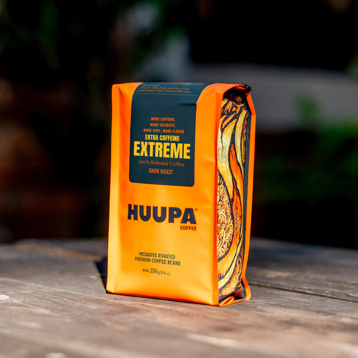 Orange coffee bag labeled 'HUUPA Coffee' with 'EXTREME' text on a wooden surface.