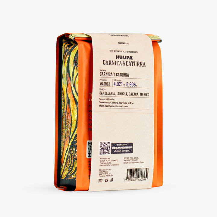 A package of Huupa Garnica & Caturra washed coffee, shown from the side. The packaging features a bright orange border, a cream-colored paper label with black text, and a colorful marbled pattern on the left side.
